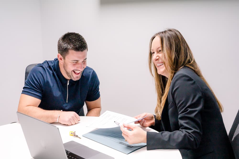 Letting agents laughing and discussing benefits of landlords using a letting agent