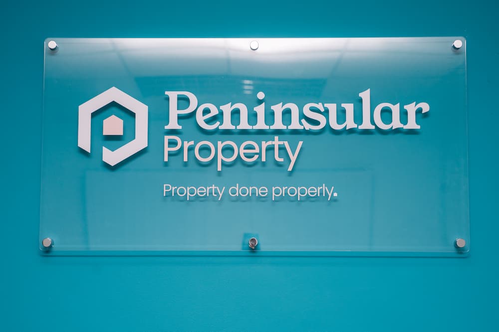 The Peninsular Property logo on a blue background